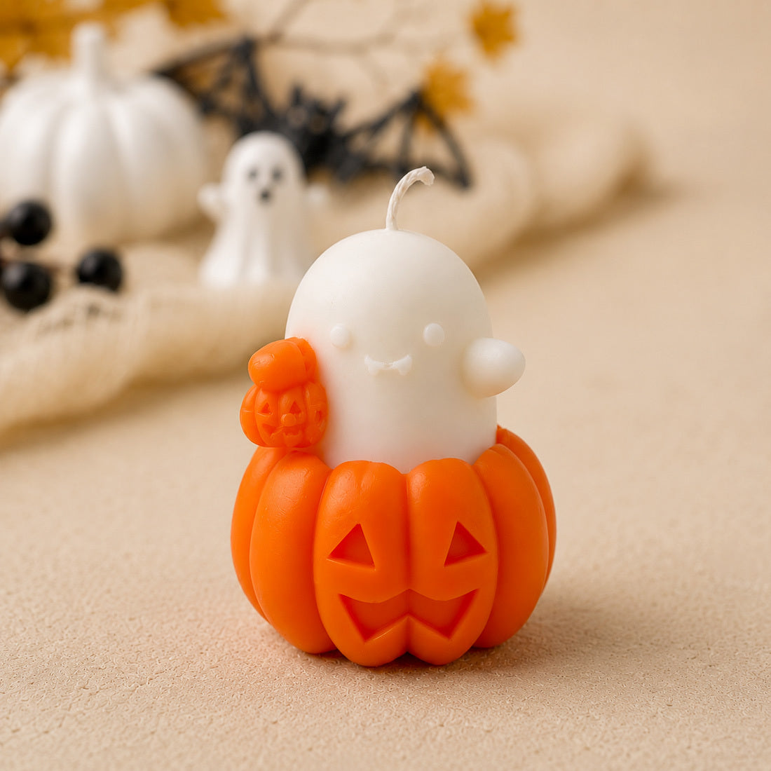 Bougie fantôme blanche assise sur une citrouille orange sculptée
