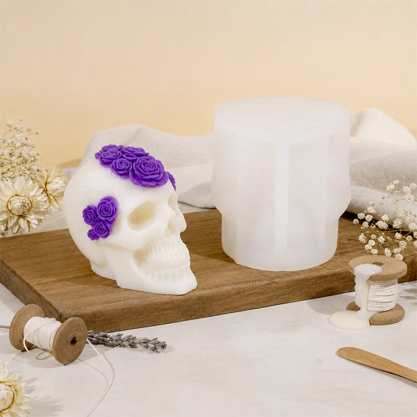 Bougie crâne fleuri et son moule en silicone posés sur une planche en bois