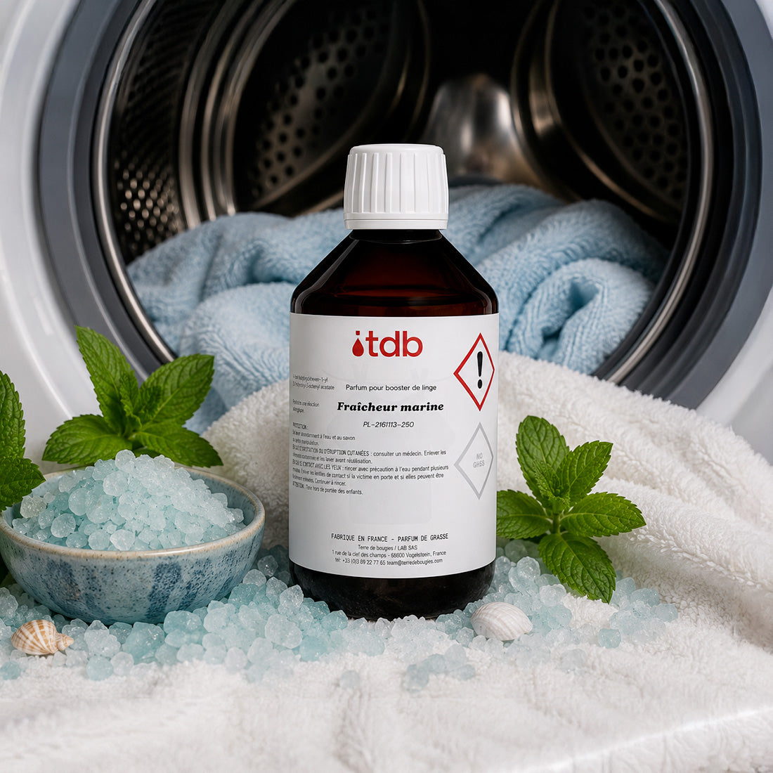Flacon du booster Fraicheur marine avec sel marin et menthe devant un lave-linge
