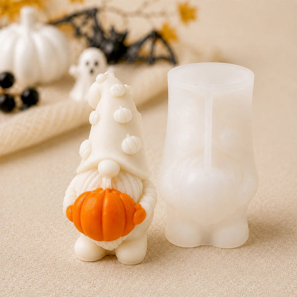 Bougie lutin de Noël avec sa citrouille orange à côté de son moule en silicone